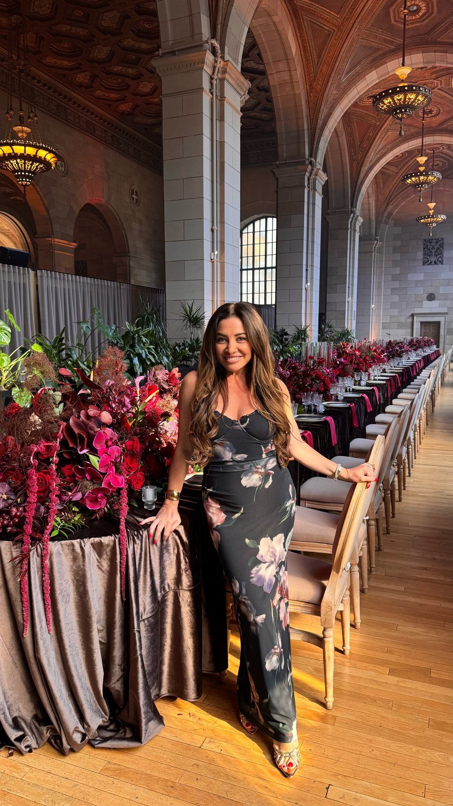 Maddy K beside a long table in a grand hall