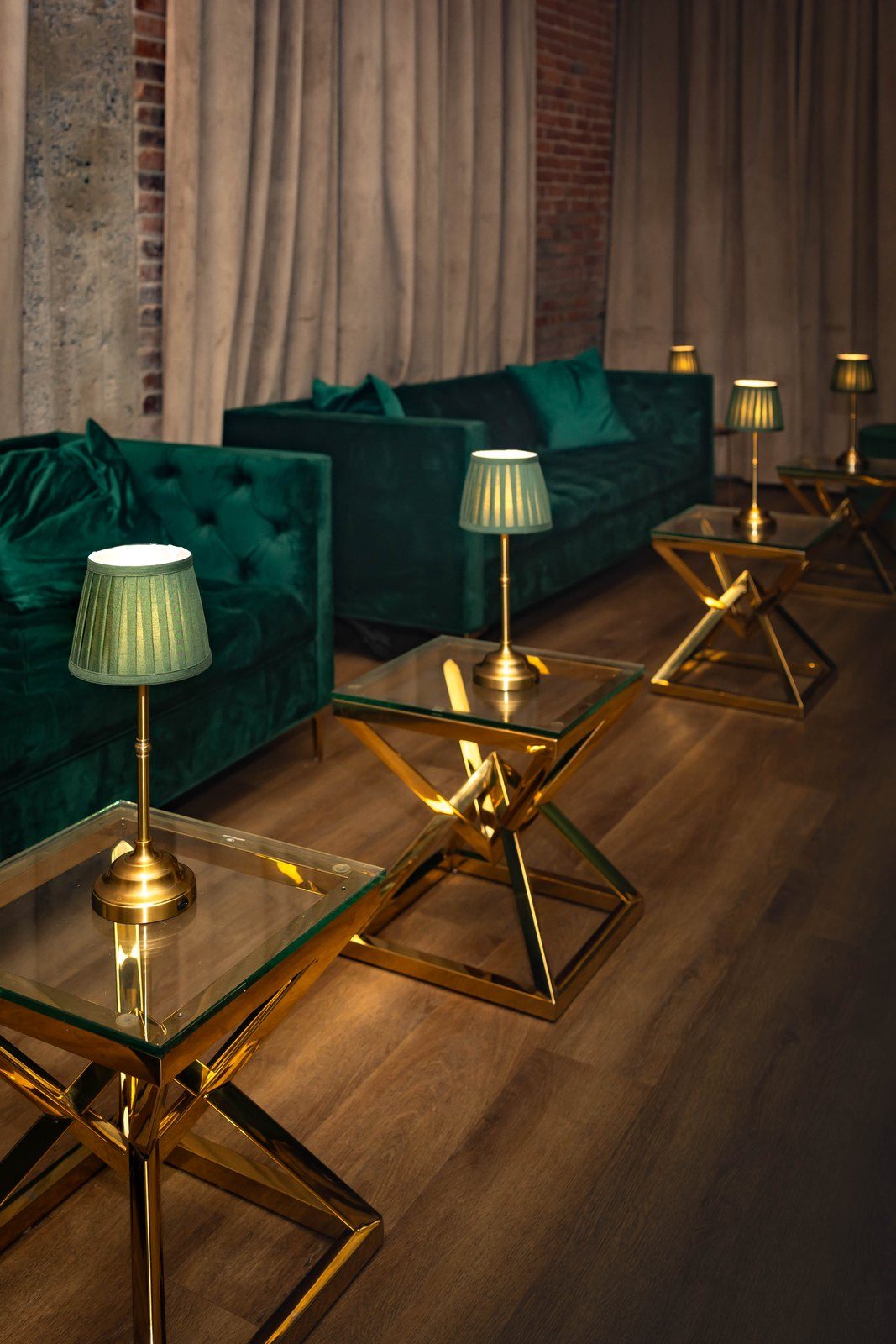 Green velvet banquettes and brass lamps