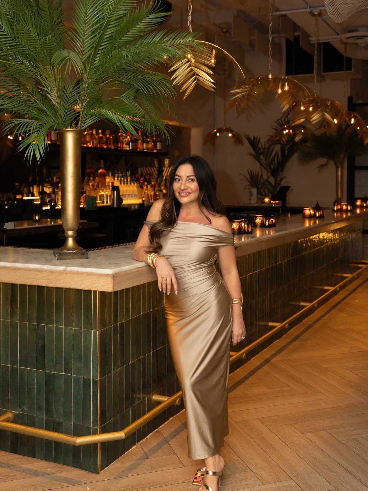 Maddy K at a green-tiled bar