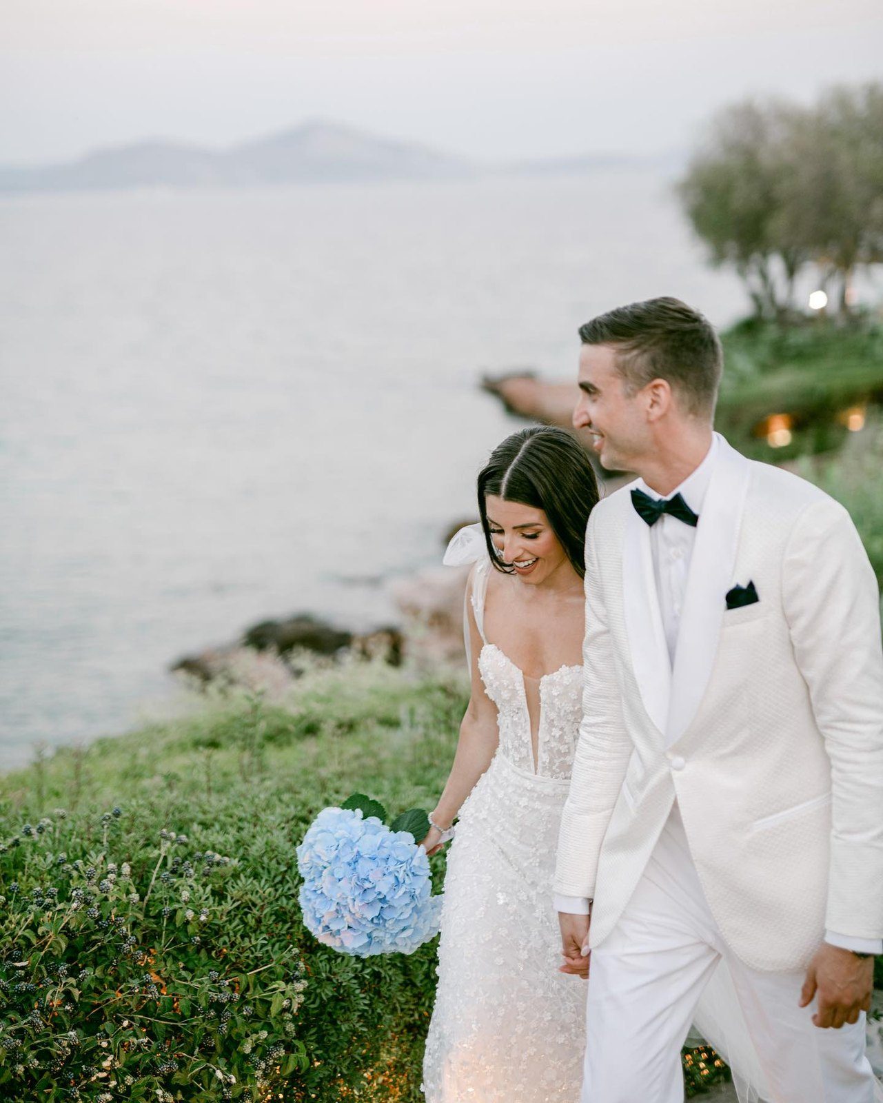 A couple walking the shoreline at a destination wedding