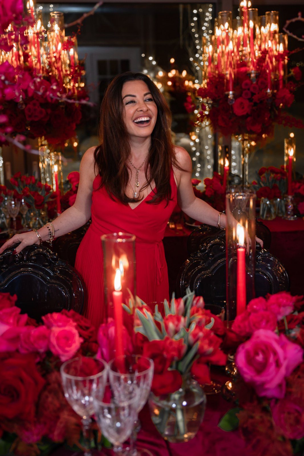 Maddy K among red florals and candlelight