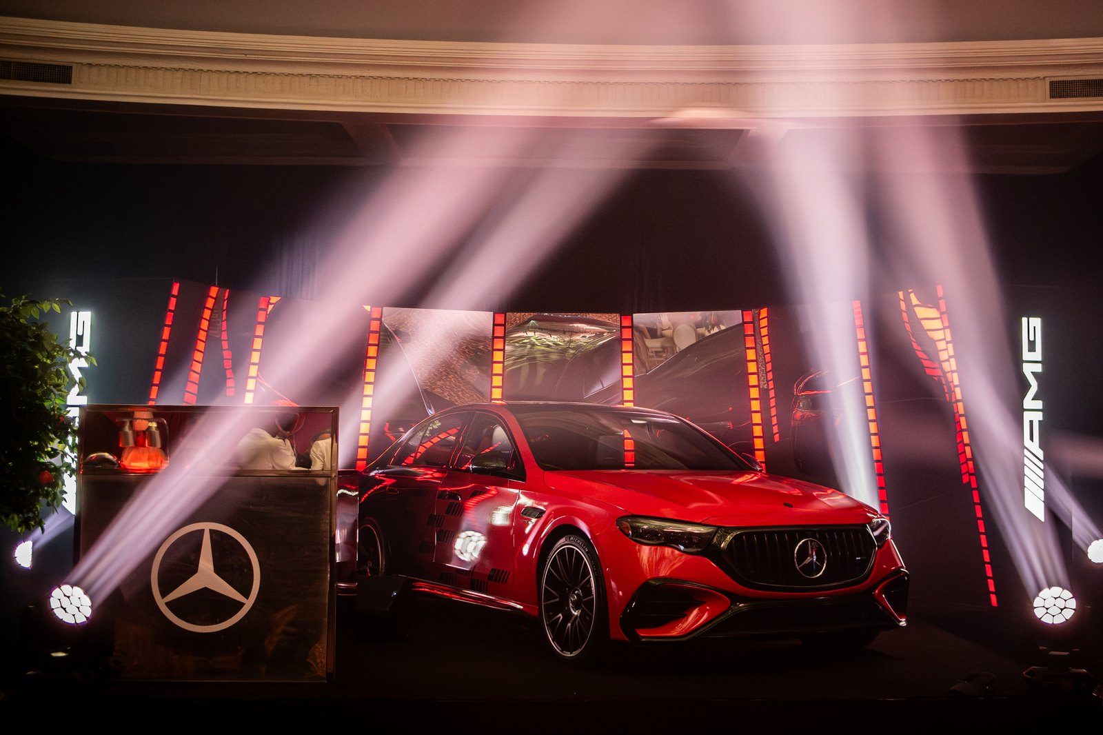 A red Mercedes on a lit stage at the Grand Prix party