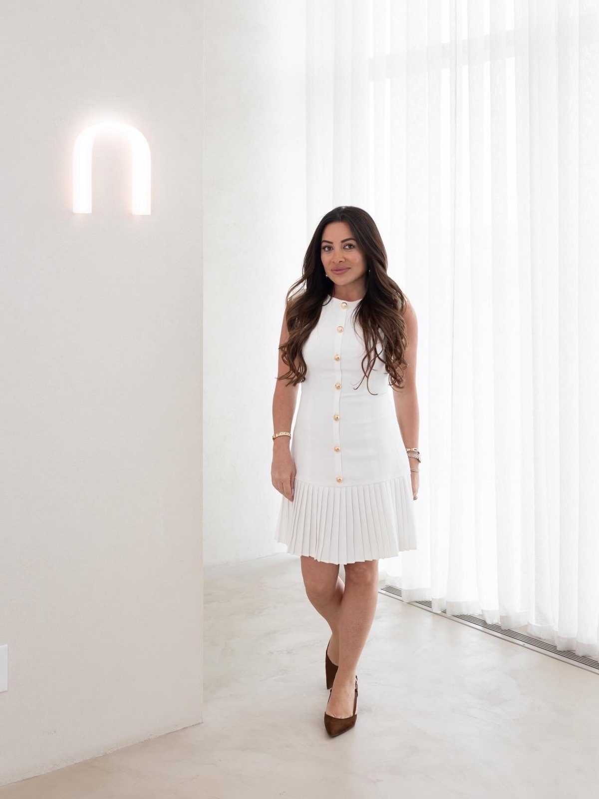 Maddy K in white in a sunlit studio