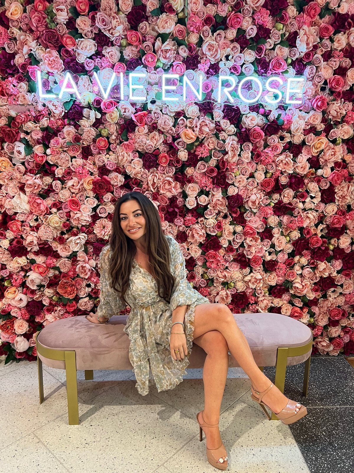 Maddy K before a wall of roses